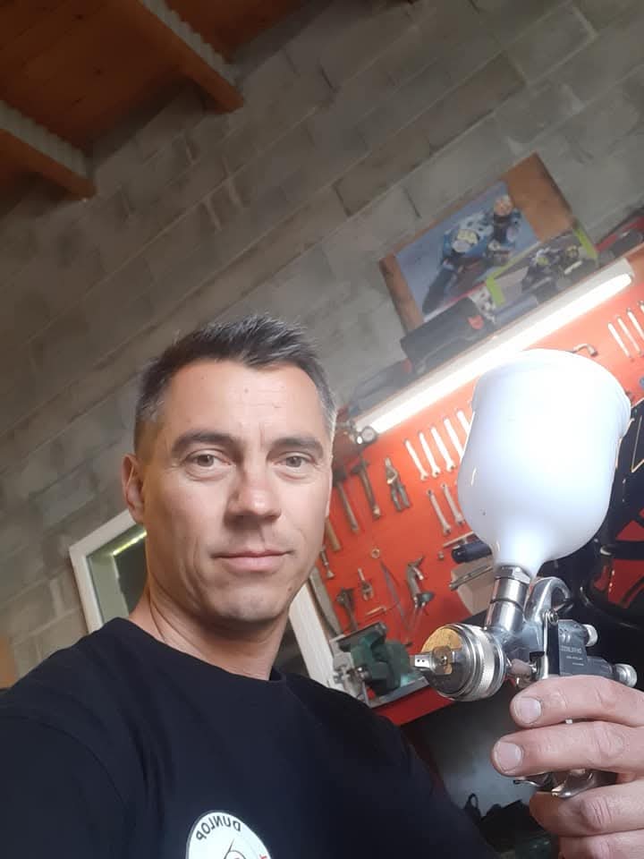 Le mécanicien de ROUBY SEB MOTO avec son pistolet à peinture dans l'atelier.