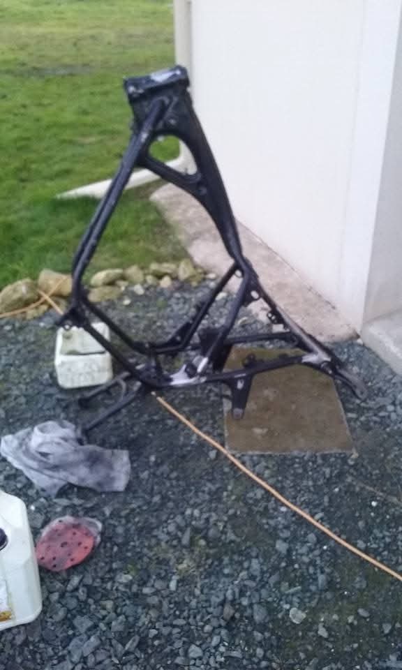 Cadre Honda démonté et posé au sol, démontage complet avant préparation et peinture.